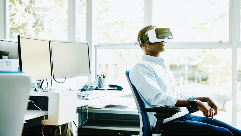 Uomo che usa strumenti per la realtà virtuale al lavoro