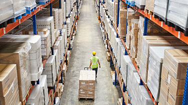 worker passing in the large warehouse aisle