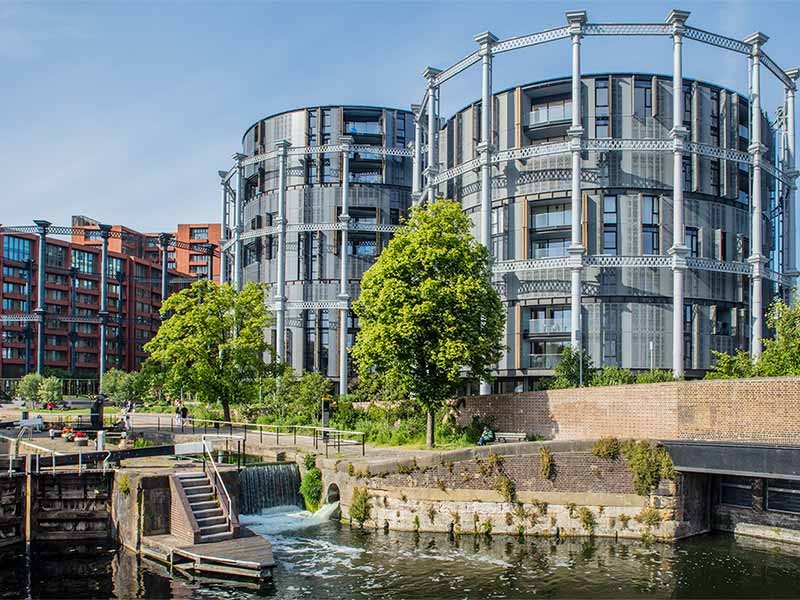 A residential development with a public park on the edge of a canal in a city